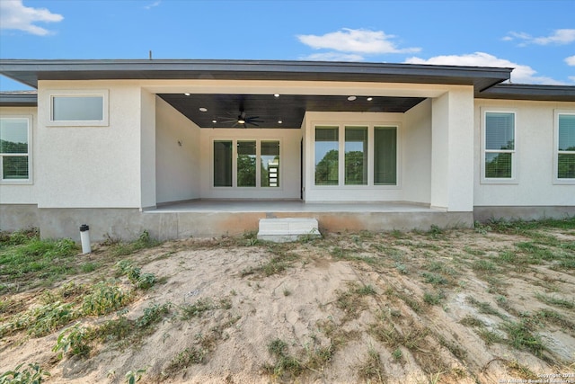 rear view of house with ceiling fan and a patio area