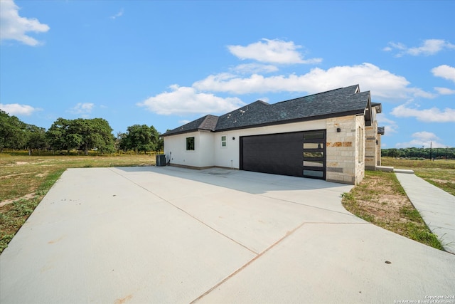 view of property exterior featuring a garage and central air condition unit