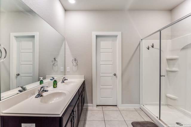 bathroom with tile patterned flooring, vanity, and walk in shower