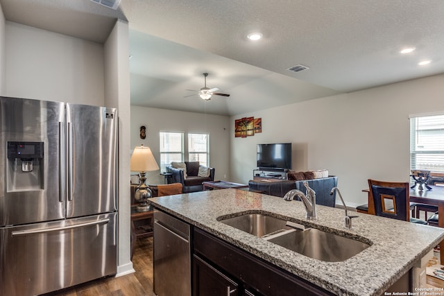 kitchen featuring stainless steel appliances, plenty of natural light, a center island with sink, and sink