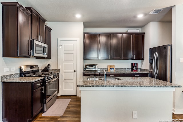 kitchen featuring a center island with sink, dark hardwood / wood-style floors, sink, and appliances with stainless steel finishes