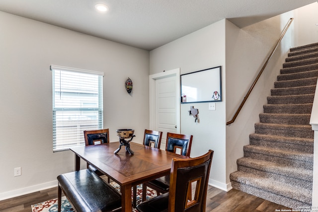 dining room featuring a textured ceiling and dark wood-type flooring