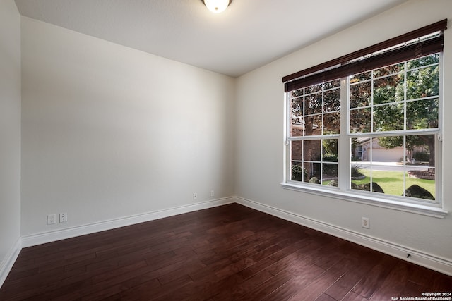 spare room featuring dark hardwood / wood-style floors and plenty of natural light