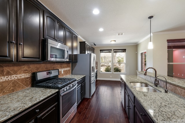 kitchen with stainless steel appliances, sink, pendant lighting, light stone counters, and dark hardwood / wood-style flooring