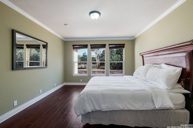 bedroom featuring dark wood-type flooring, ornamental molding, and a textured ceiling