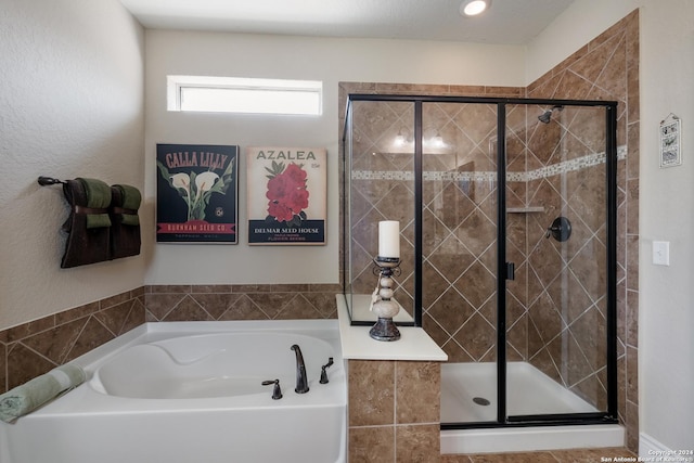 full bathroom with a shower stall and a bath