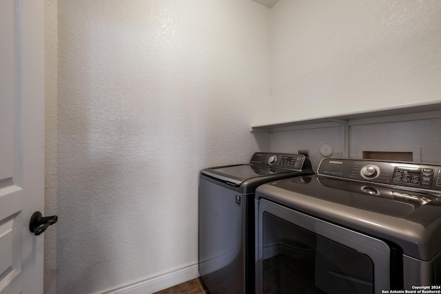 laundry area with washing machine and clothes dryer, baseboards, and laundry area