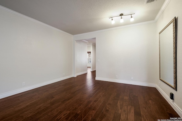 spare room with dark wood finished floors, visible vents, ornamental molding, baseboards, and a textured ceiling