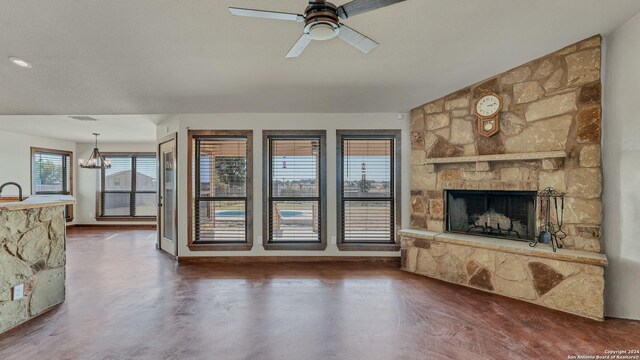 165 Lakeview Cir, La Vernia, TX 78121 - unfurnished living room featuring ceiling fan with notable chandelier and a fireplace