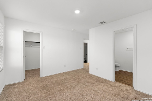 385 Soapstone Pass, Maxwell, TX 78656 - unfurnished bedroom featuring a spacious closet, visible vents, connected bathroom, baseboards, and light colored carpet