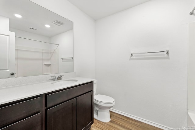 full bathroom featuring vanity, hardwood / wood-style flooring, toilet, and tub / shower combination