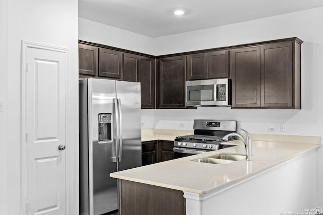 kitchen featuring stainless steel appliances, dark brown cabinets, sink, and kitchen peninsula