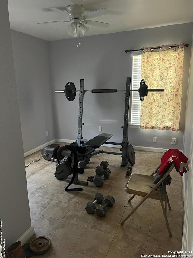 exercise room featuring light tile patterned floors and ceiling fan