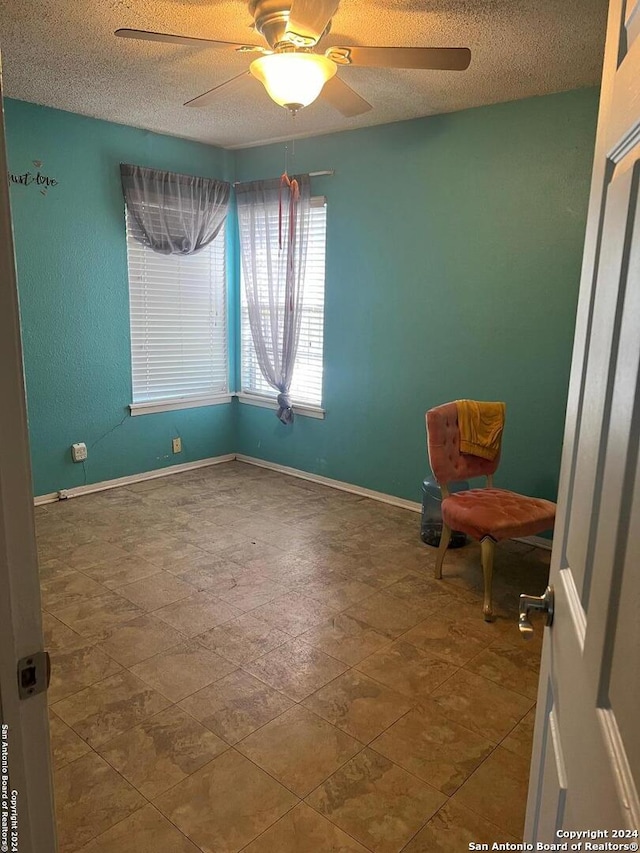 interior space with ceiling fan and a textured ceiling