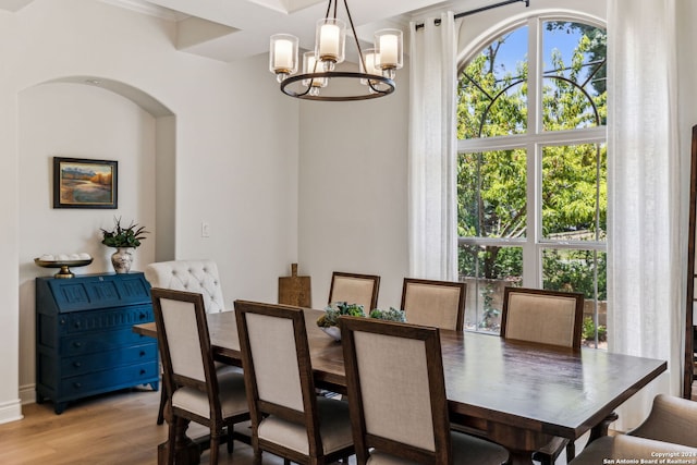 dining space with light hardwood / wood-style floors and a notable chandelier