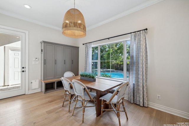 dining space featuring ornamental molding and light hardwood / wood-style floors