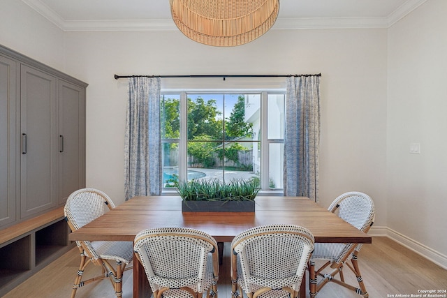 dining area with light hardwood / wood-style flooring and crown molding