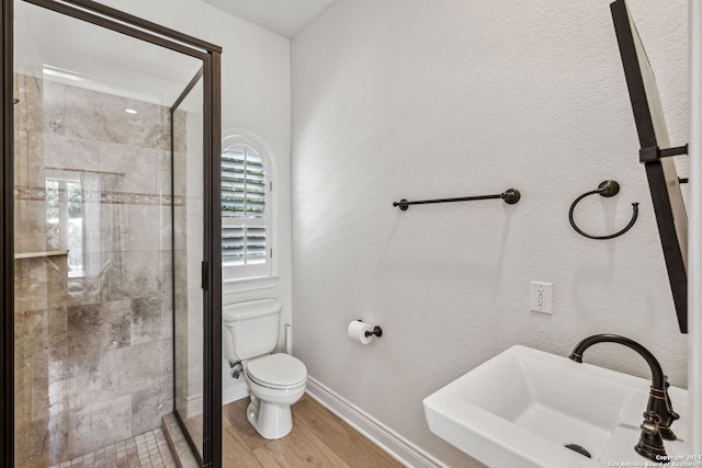 bathroom with sink, hardwood / wood-style flooring, toilet, and an enclosed shower