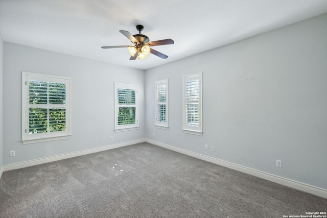 empty room featuring ceiling fan, carpet floors, and plenty of natural light