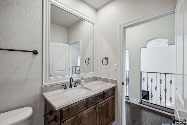 bathroom featuring vanity, toilet, and hardwood / wood-style floors