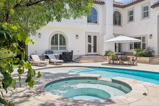 view of swimming pool with french doors, a patio area, and an in ground hot tub