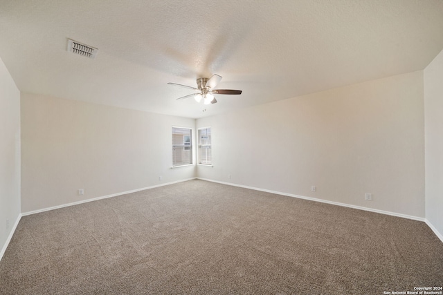 spare room featuring ceiling fan, carpet, and a textured ceiling