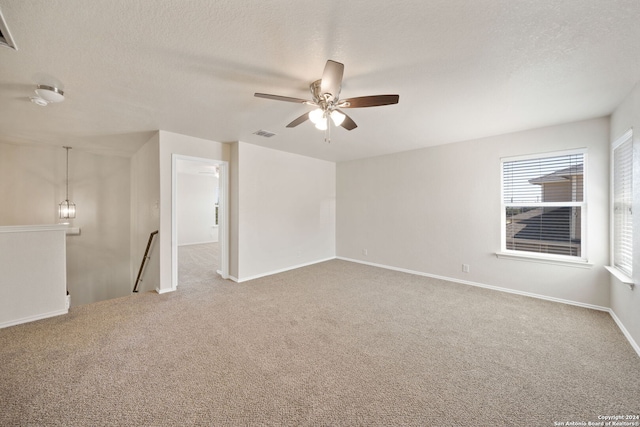 carpeted empty room with ceiling fan and a textured ceiling