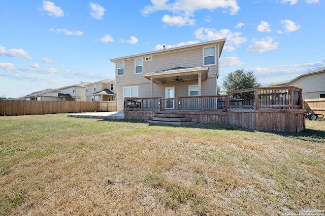 rear view of property featuring ceiling fan, a patio area, and a yard