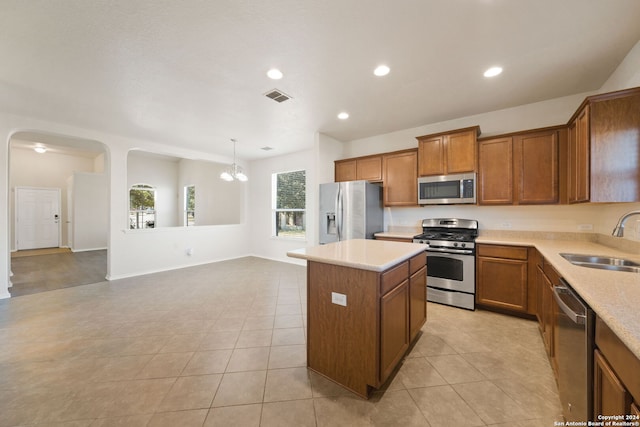 kitchen with sink, hanging light fixtures, a chandelier, a kitchen island, and appliances with stainless steel finishes