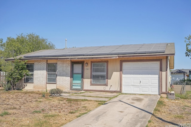 ranch-style home with solar panels and a garage