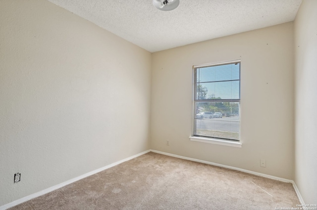 carpeted spare room with a textured ceiling