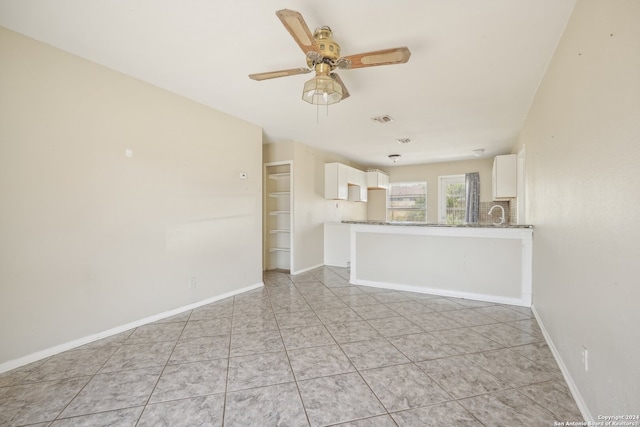 unfurnished living room with ceiling fan and light tile patterned floors