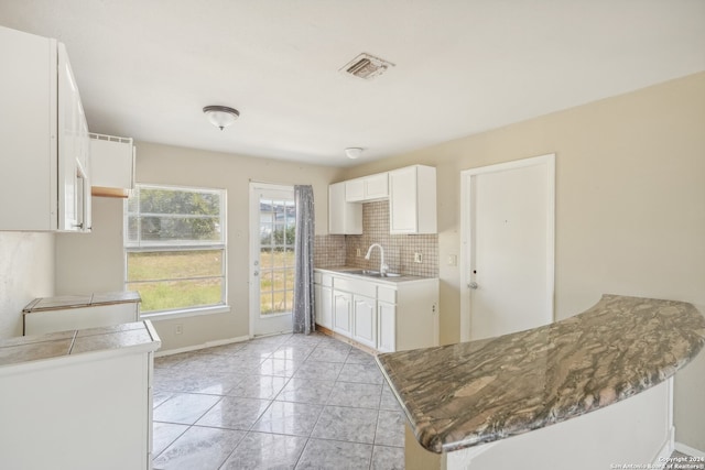 kitchen featuring white cabinetry, backsplash, and kitchen peninsula