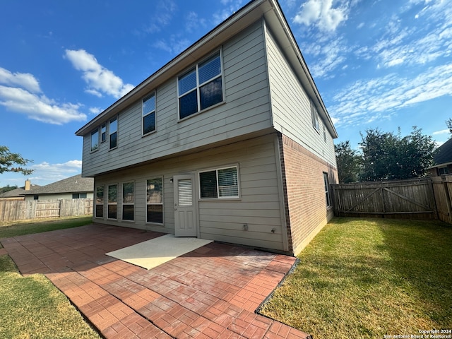 rear view of property with a yard and a patio area