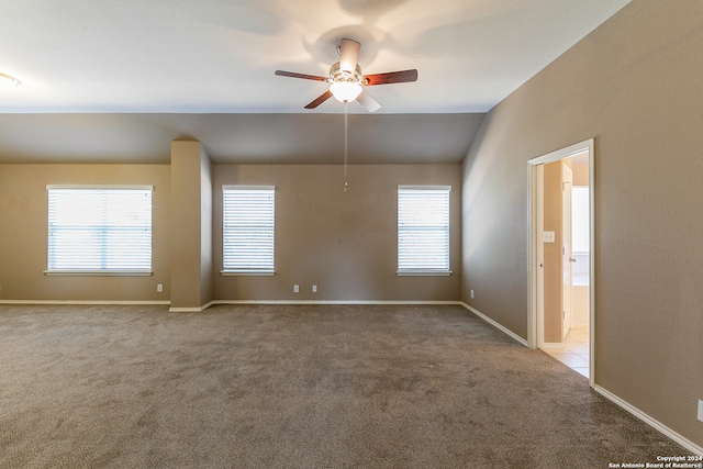 carpeted spare room featuring a healthy amount of sunlight and ceiling fan