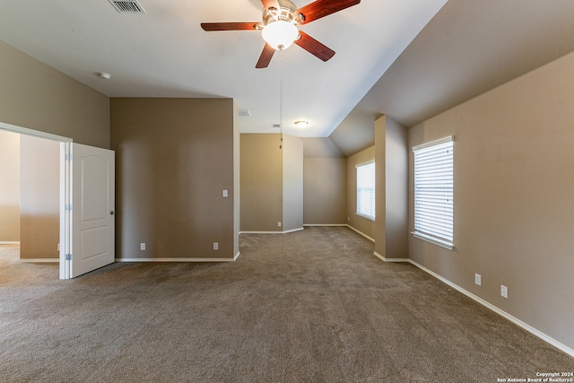 carpeted spare room with ceiling fan and vaulted ceiling