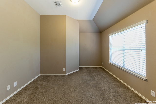 additional living space with dark carpet and vaulted ceiling