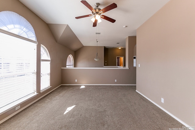 carpeted empty room featuring lofted ceiling, a healthy amount of sunlight, and ceiling fan