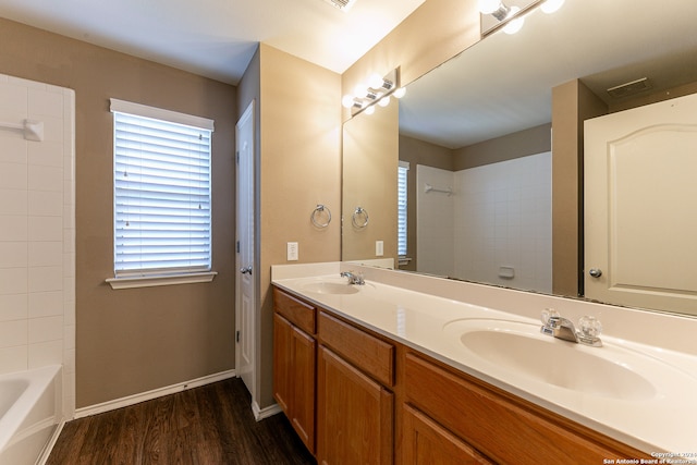 bathroom featuring vanity, hardwood / wood-style floors, and tiled shower / bath combo