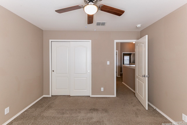 unfurnished bedroom with a closet, carpet, and ceiling fan