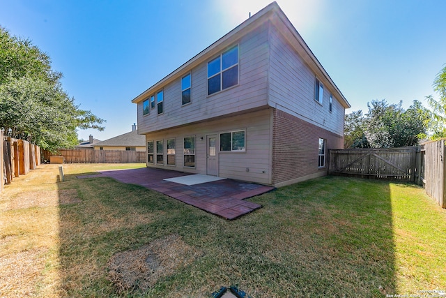 rear view of house with a yard and a patio area