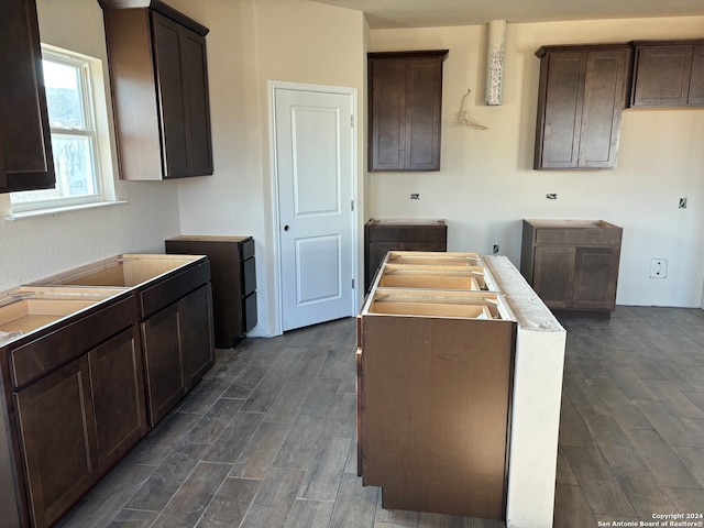 kitchen with dark brown cabinets and dark hardwood / wood-style flooring