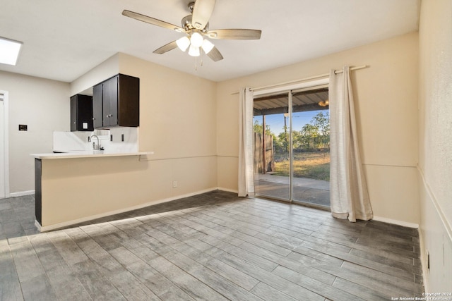 interior space with ceiling fan, kitchen peninsula, and dark hardwood / wood-style flooring