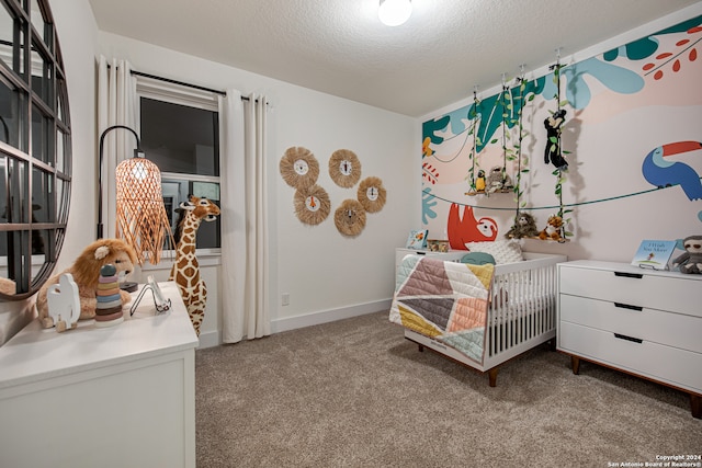 bedroom with a nursery area, light colored carpet, and a textured ceiling