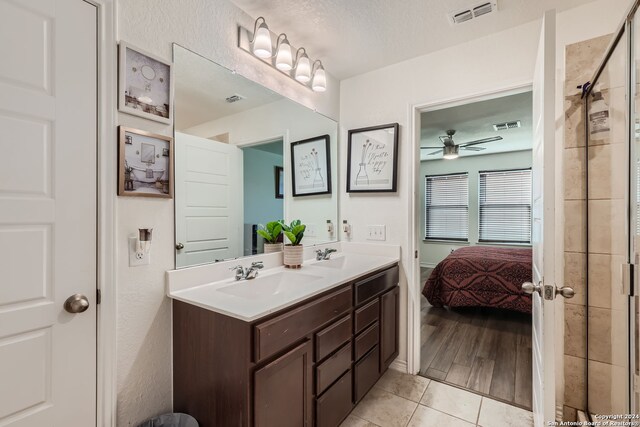 bathroom featuring a shower with door, wood-type flooring, vanity, a textured ceiling, and ceiling fan