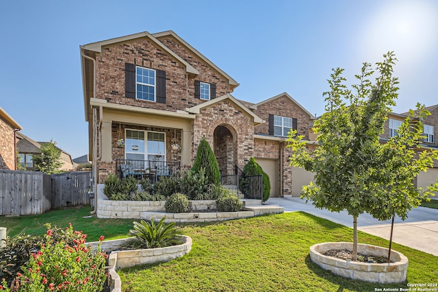 view of front facade with a front yard, a garage, and covered porch