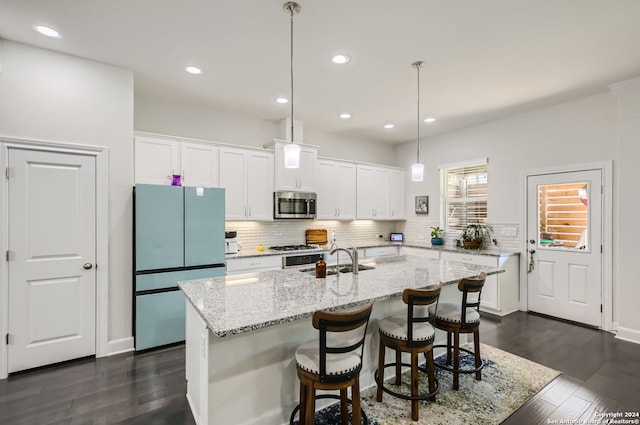 kitchen with a kitchen island, white cabinetry, decorative light fixtures, and stainless steel appliances