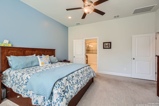 bedroom with ensuite bath, light colored carpet, and ceiling fan