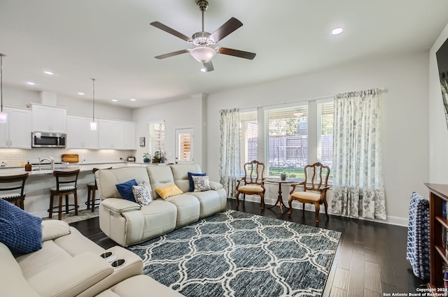 living room with ceiling fan and dark hardwood / wood-style flooring