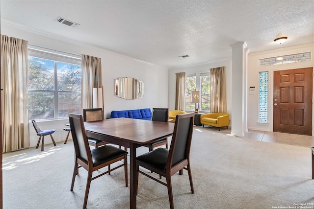 dining room with crown molding, a textured ceiling, and light colored carpet